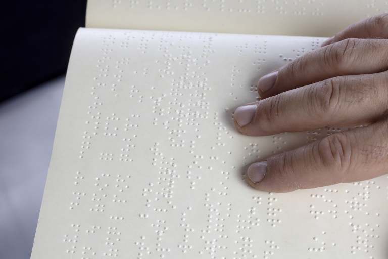 Hand reading braille page