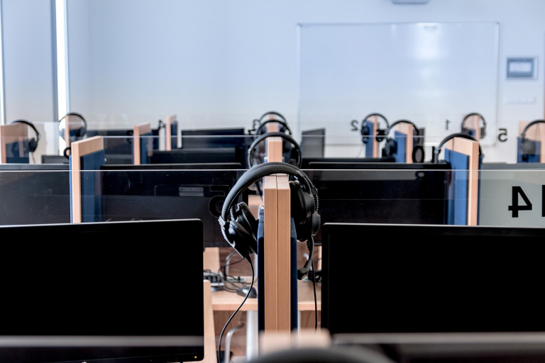 rows of cubicles with headsets hanging on walls