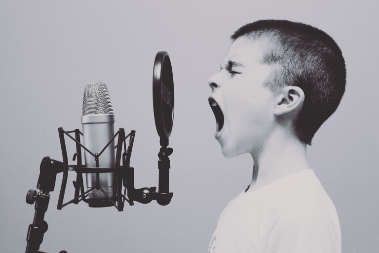 Boy shouting into old-fashioned microphone