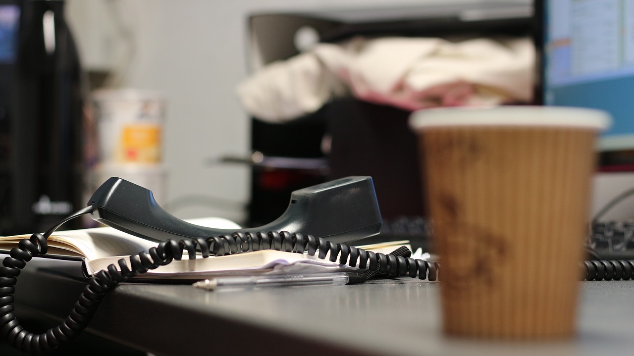 desk with phone handset off receiver