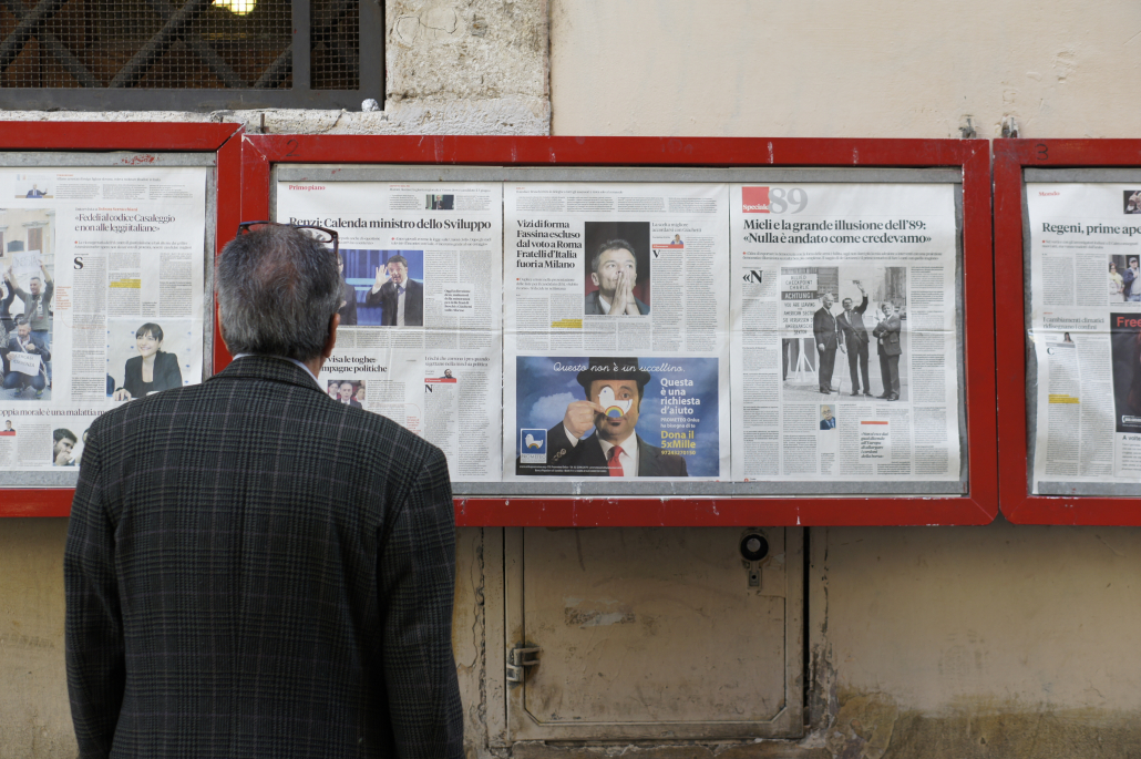 Man looking at newspaper display box